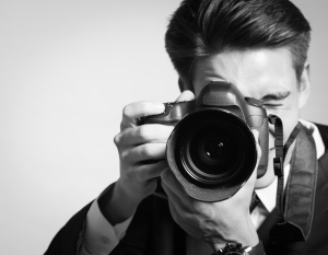 Male Portrait Photographer Holding a Big Camera